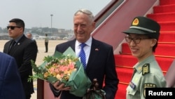 2018年6月26日,时任美国国防部长吉姆·马蒂斯(Jim Mattis)抵达中国北京机场时接受中国军人献花。 (路透社照片)