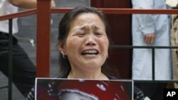 一名妇女2009年5月8日在北京卫生部前举着因食用毒奶粉而死亡的孙女照片,要求当局伸张正义。(资料照片)