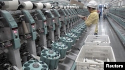 中国新疆阿克苏雅戈尔集团的棉纺织厂工人在工作。(2015年12月1日)
