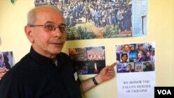 2014年9月10日,纽约圣乔治学院的彼得·谢什卡牧师指着走廊墙壁上的海报,上面显示一些被亲俄分离分子打死的乌克兰人。