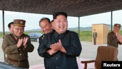 Lãnh tụ Triều Tiên Kim Jong Un tươi cười theo dõi vụ phóng một phi đạn Hwasong-12 trong một bức hình không đề ngày tháng do Thông tấn xã trung ương Triều Tiên (KCNA) công bố vào ngày 16 tháng 9, 2017.