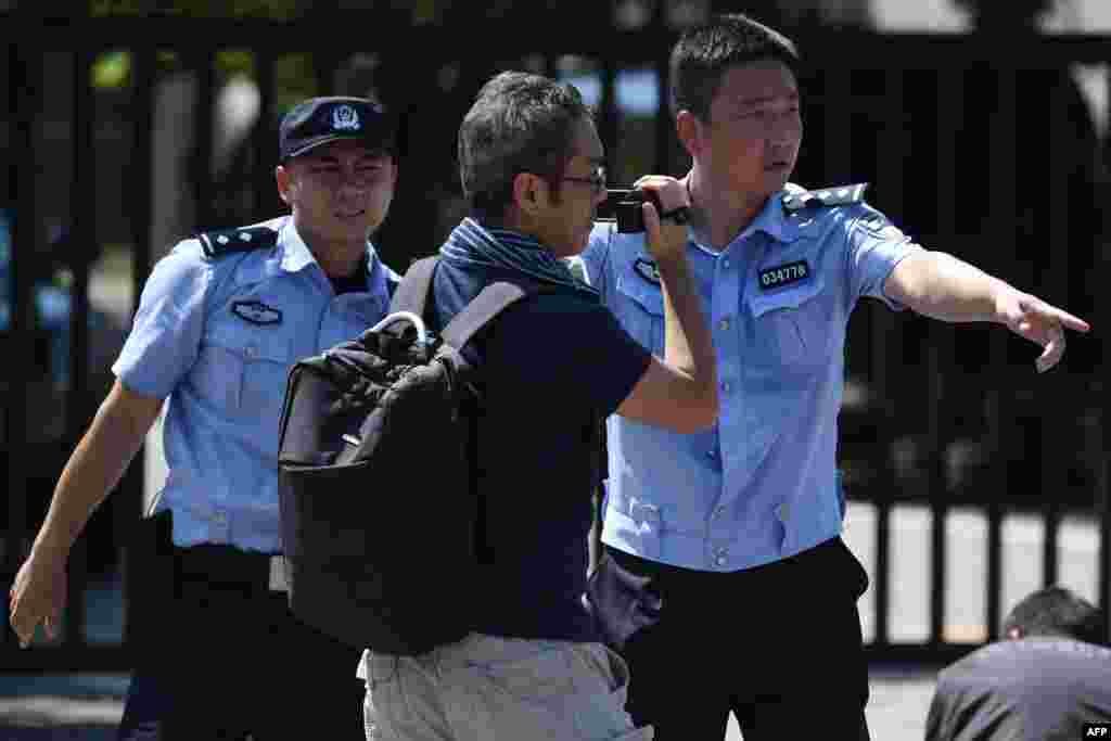 2018年7月26日，美国驻北京大使馆外的爆炸现场，中国警察推开摄影师。