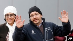 被伊朗当局释放的华盛顿邮报驻德黑兰首席记者杰森·雷载安和亲属在德国一家医疗中心前向媒体挥手致意。(2016年1月20日)