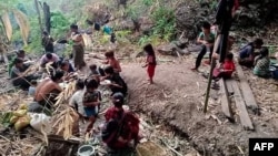 တောထဲတွင် ထွက်ပြေးခိုလှုံနေကြရသည့် မင်းတပ် စစ်ရှောင်များ (ဓာတ်ပုံ - AFP PHOTO / CHIN WORLD)