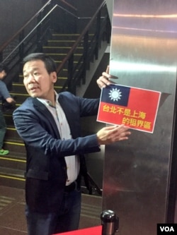 国民党籍台北市议员钟小平向媒体展示抗议标语。他指责柯文哲市长身份款待沙海林是自我矮化。(美国之音林枫拍摄)