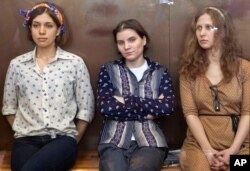 2012年8月3日,俄罗斯女子朋克乐队Pussy Riot三成员被关在玻璃笼内在莫斯科出庭。自左至右:娜杰日达.托罗孔尼科娃、叶卡捷林娜.萨穆谢维奇、玛丽娅.阿廖欣娜。