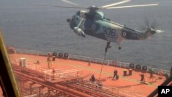 资料照片:伊朗海军2023年4月28日发布的视频显示,伊朗海军陆战队员在阿曼湾扣押油轮时从直升机上降落到 “优势甜”号上。(美联社照片)