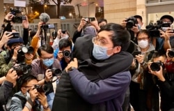 有被告家属得知保释申请被拒绝,在法院大楼外抱着元朗区议员林进痛哭(美国之音/汤惠芸)