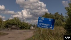 在乌克兰苏梅州,乌克兰军人驾驶一辆装甲军车行驶在通往俄罗斯边界的公路上。(2024年8月14日)