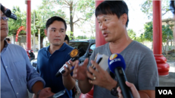 与海吉利号渔船随行的凤凰卫视记者(右二)采访活动发言人罗强飞(右一)