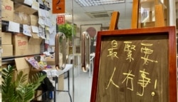石墙花位于荔枝角的办公室门外,放有写上“最紧要人冇事”(最重人没事)的黑板 (美国之音/汤惠芸)