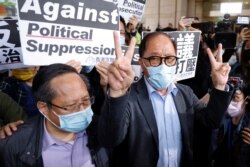 被告之一的何俊仁(左)与民主党前主席杨森离开法院向记者发表声明