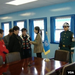 游客在非军事区停战谈判会议室内听导游讲解（美国之音王南拍摄）