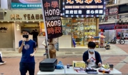 Michael(左)认同家长为了子女有更好学习及成长环境带同子女移民,不需要被国安法“维稳教材”洗脑。(美国之音 / 汤惠芸)