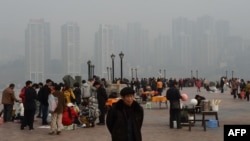 2013年2月,重庆居民在朝天门公园,背景是新建的社会保障房。薄熙来由于社会保障房等项目而在当地得人心,但也留下巨额债务