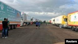 2023年10月17日,在埃及拉法,载有人道主义援助物资的卡车等待拉法过境点重新开放,以便在以色列和哈马斯之间持续不断的冲突中进入加沙。(路透社照片)