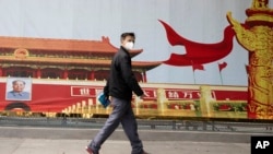 湖北武汉一名居民走过街头一幅北京天安门的招贴画。