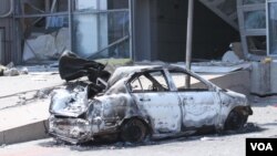 天津爆炸事故现场,核心爆炸区周围多座居民楼窗户被震碎,高速公路桥梁受损,多辆大货车被炸翻,小汽车起火或被砸,多名当地居民仍逗留在事故现场。(美国之音东方拍摄)