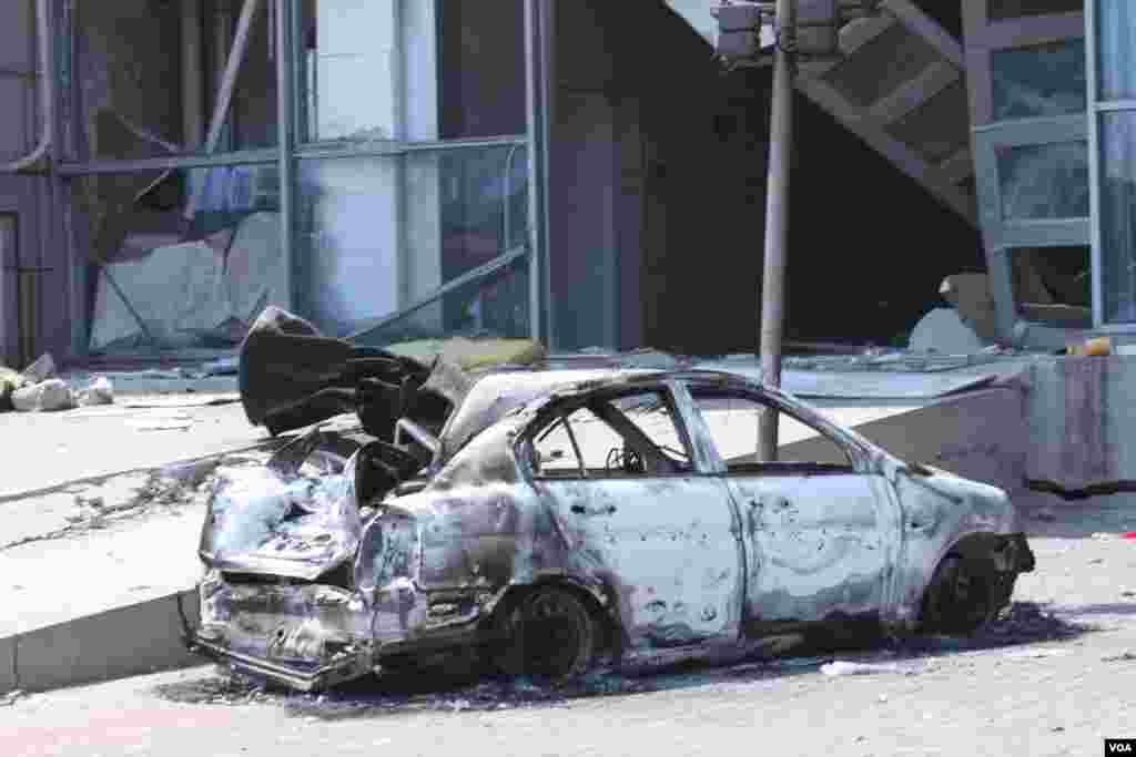 天津爆炸事故现场,核心爆炸区周围多座居民楼窗户被震碎,高速公路桥梁受损,多辆大货车被炸翻,小汽车起火或被砸,多名当地居民仍逗留在事故现场。(美国之音记者东方拍摄)