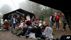 一群移民在塞尔维亚贝尔格莱德以西大约100公里处的塞尔维亚与克罗地亚的边界等候过境。(2015年10月18日)