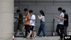 在北京的字节跳动公司雇员边走路边看手机。(2020年7月6日)