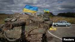 在伊久姆镇附近,一辆被缴获的俄军坦克插上了乌克兰旗帜。(2022年9月19日)