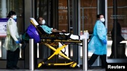 纽约大学兰贡医院的医护人员正在转移一名戴口罩的病人。(2020年5月3日)