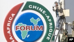 资料照片:一名中国男子在北京天安门广场中非合作论坛标志附近修理安全摄像头。(2006年10月29日)