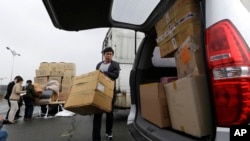 来自朝鲜开城的韩国工人2013年4月9日抵达板门店村边界附近的海关,移民和检疫局之后搬运货物纸箱。