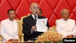 Quốc Vương Campuchia Norodom Sihamoni đọc một tài liệu khi đến dự một buổi họp tại Thượng viện với