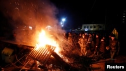 在乌克兰中部新桑扎里地区,示威者放火并竖起路障,抗议一架载有从遭受新型冠状病毒袭击的中国湖北省撤离人员的飞机的到来(2020年2月20日)。