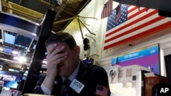 纽约证券交易所一名交易员面临星期一股市开盘时的暴跌。(美联社2020年3月9日资料照)