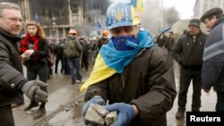 Người biểu tình chống chính phủ nhặt đá để chống trả với cảnh sát tại trung tâm thủ đô Kyiv, ngày 19/2/2014.