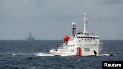 一艘中国巡逻舰在南中国海上行驶，它背后便是饱受争议的石油钻井平台 （资料照）