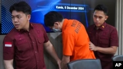 印尼移民警察把最近被逮捕的中国公民闫振兴(音译)带到雅加达的一次记者会,这名男子因据称为网络赌博犯罪团伙洗钱而被中国通缉并列入国际刑警组织红通名单。(2024年12月5日)