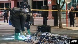 韩国国防部发布照片显示,韩国军方人员在首尔街头检查据信是朝鲜释放的气球带来的不明垃圾物品。(2024年6月2日)