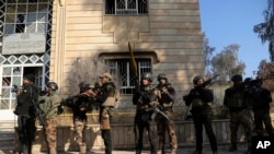 在摩苏尔东部打击伊斯兰国激进分子的战斗中,伊拉克特种部队在摩苏尔大学里走动(2017年1月14日)