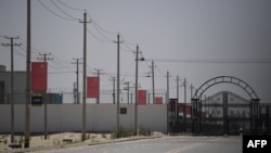 资料照:新疆和田一处据信为关押着维吾尔穆斯林少数民族的集中营设施外沿路高挂中国国旗。(2019年5月31日)