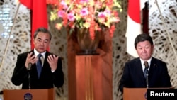 资料照:日本外相茂木敏充(右)和中国国务委员兼外交部长王毅在东京举行会谈后出席记者会。(2019年11月25日)