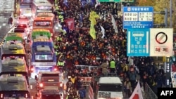 2024年12月4日,参加反对韩国总统尹锡悦游行的抗议者前往首尔总统府。(法新社)