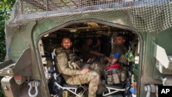 在靠近乌俄边界的乌克兰苏梅州,从俄罗斯库尔斯克州返回的乌克兰军人坐在一辆装甲车内。(2024年8月14日)