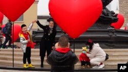 北京的一名家长和孩子一起游玩拍照。(2021年2月13日)