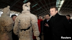 2018年1月8日,法国总统马克龙在中国陕西省西安市参观秦代兵马俑博物馆,近距离观察兵马俑。