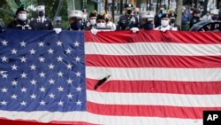 在911事件19周年纪念仪式中,当美国国歌响起时一面美国国旗在国家911纪念馆前展开。(2020年9月11日)