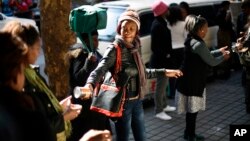 Những người tình nguyện đứng thành hàng dài chuyền thực phẩm và quần áo đến một cơ sở từ thiện