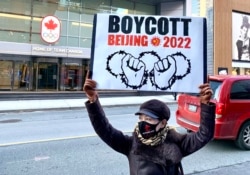 盛雪在多伦多加拿大奥委会总部外举标语抵制北京冬奥会。 （照片来自盛雪推特）
