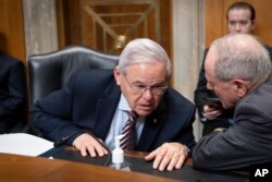 资料照片:参议院外委会主席、民主党参议员梅嫩德斯(左)与外委会资深成员、共和党参议员里施在一次有关援助乌克兰抗击俄罗斯的听证会上交谈。(2022年5月12日)