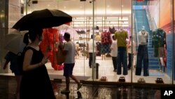 资料照片:2024年7月30日,中国顾客漫步在北京三里屯太古里的一家服装店。中国经济政策制定者预计将于10月8日制定出促进增长的政策。