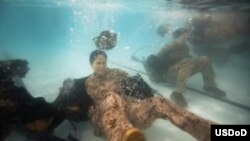 美国海军陆战队少尉斯蒂芬妮·拉科布希在海军陆战队水下生存培训项目资格测试中演练浅水摆脱辎重。(美国国防部照片)