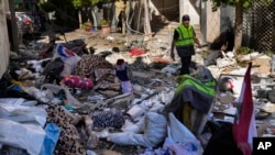 2024年10月3日,在一次空袭击中黎巴嫩贝鲁特市中心一栋多层建筑内的公寓后,一名真主党医护人员在废墟中行走。